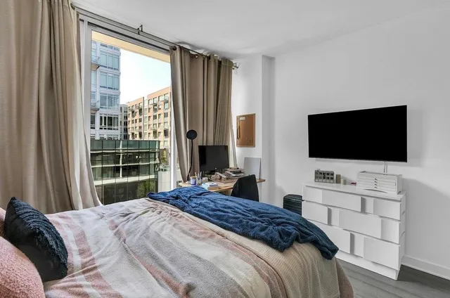 a bedroom with a bed and a flat screen tv