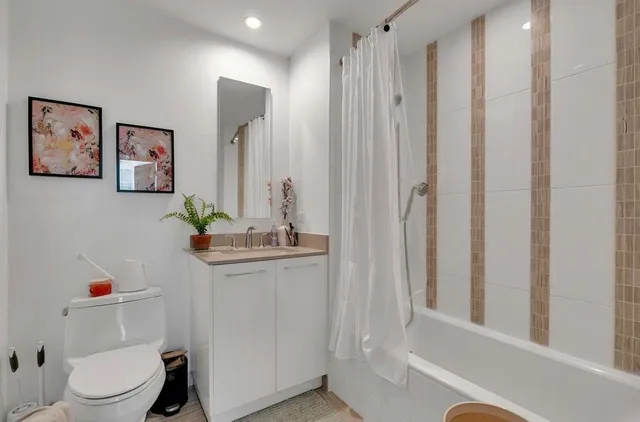 a bathroom with a sink a toilet and shower curtain