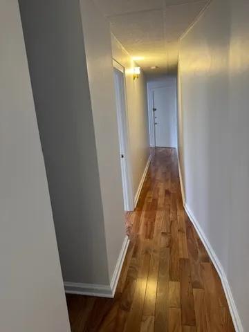 a view of hallway with wooden floor