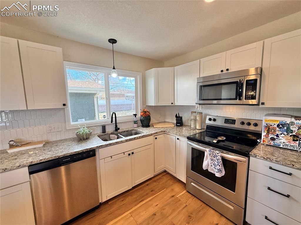 58 Duke Street Pueblo, CO 81005 - Photo 11 of 35 a kitchen with a sink stove top oven and cabinets