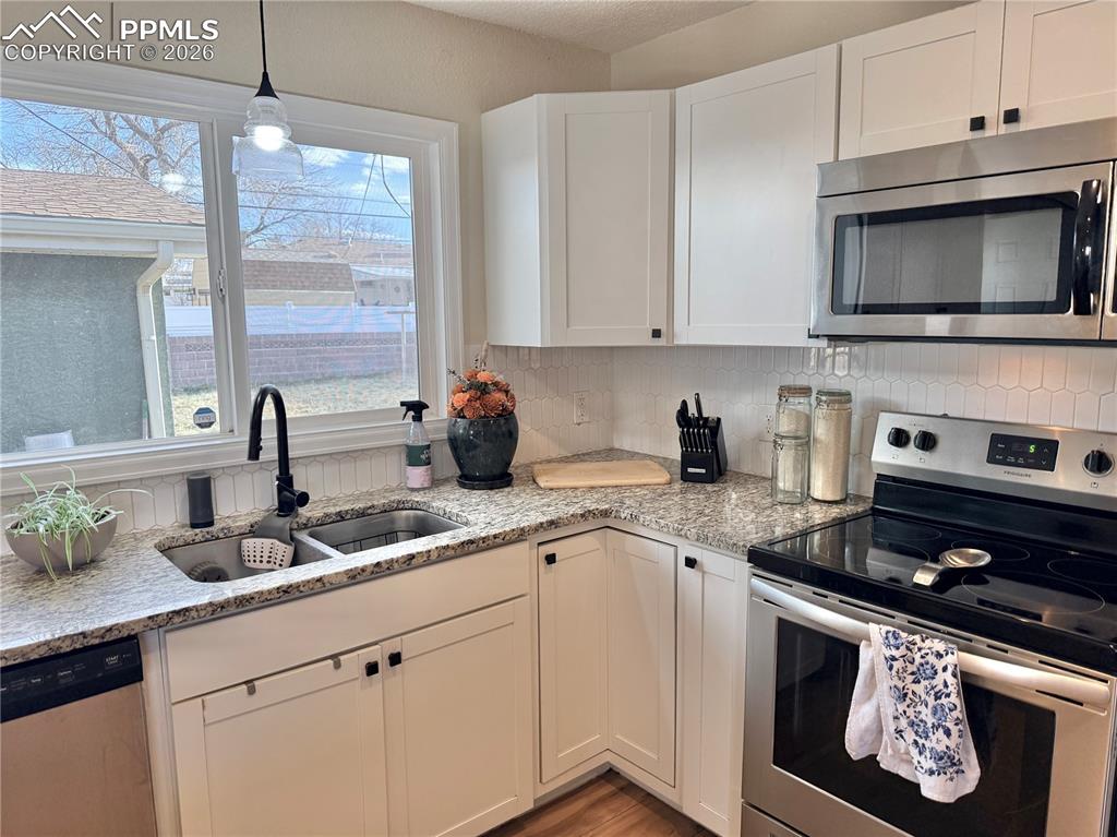 58 Duke Street Pueblo, CO 81005 - Photo 10 of 35 a kitchen with stainless steel appliances granite countertop a sink a stove and microwave