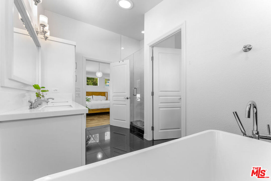 29500 Heathercliff Road, Unit 70 Malibu, CA 90265 - Photo 14 of 38 a en suite bathroom with a granite countertop sink and a mirror