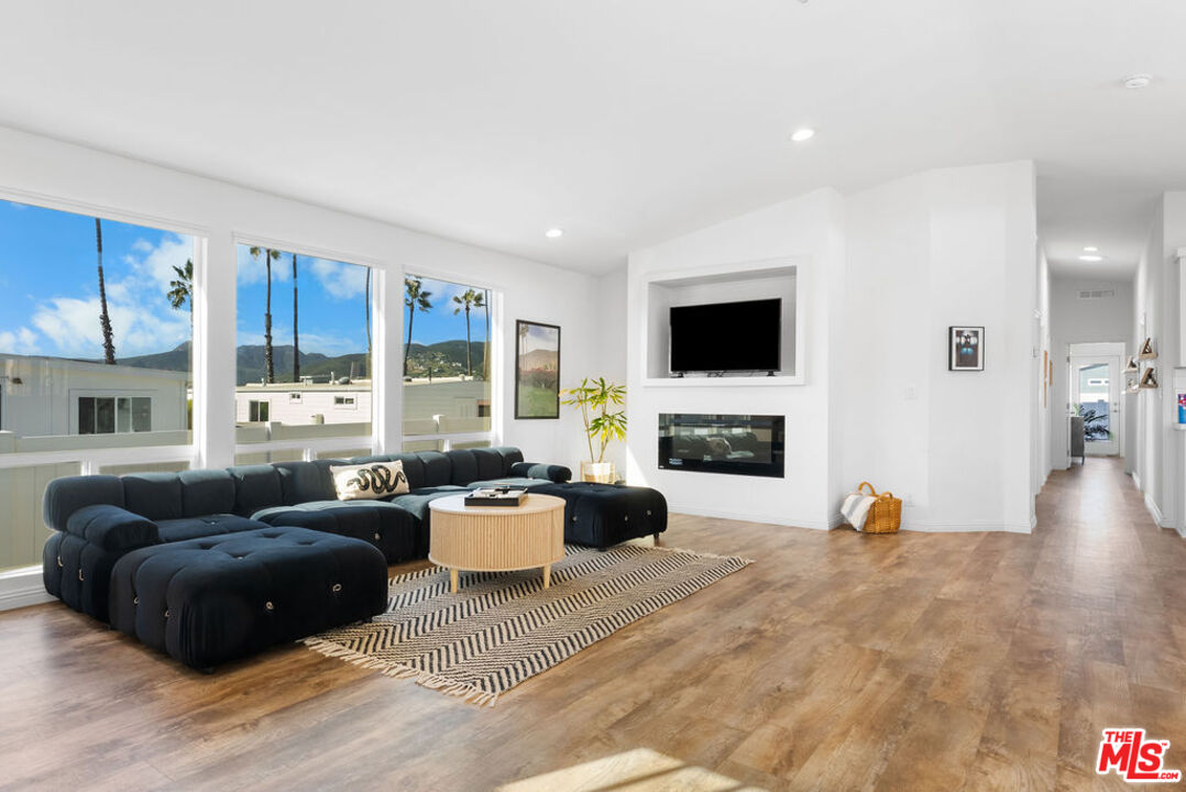 29500 Heathercliff Road, Unit 70 Malibu, CA 90265 - Photo 3 of 38 a living room with furniture a fireplace and a flat screen tv