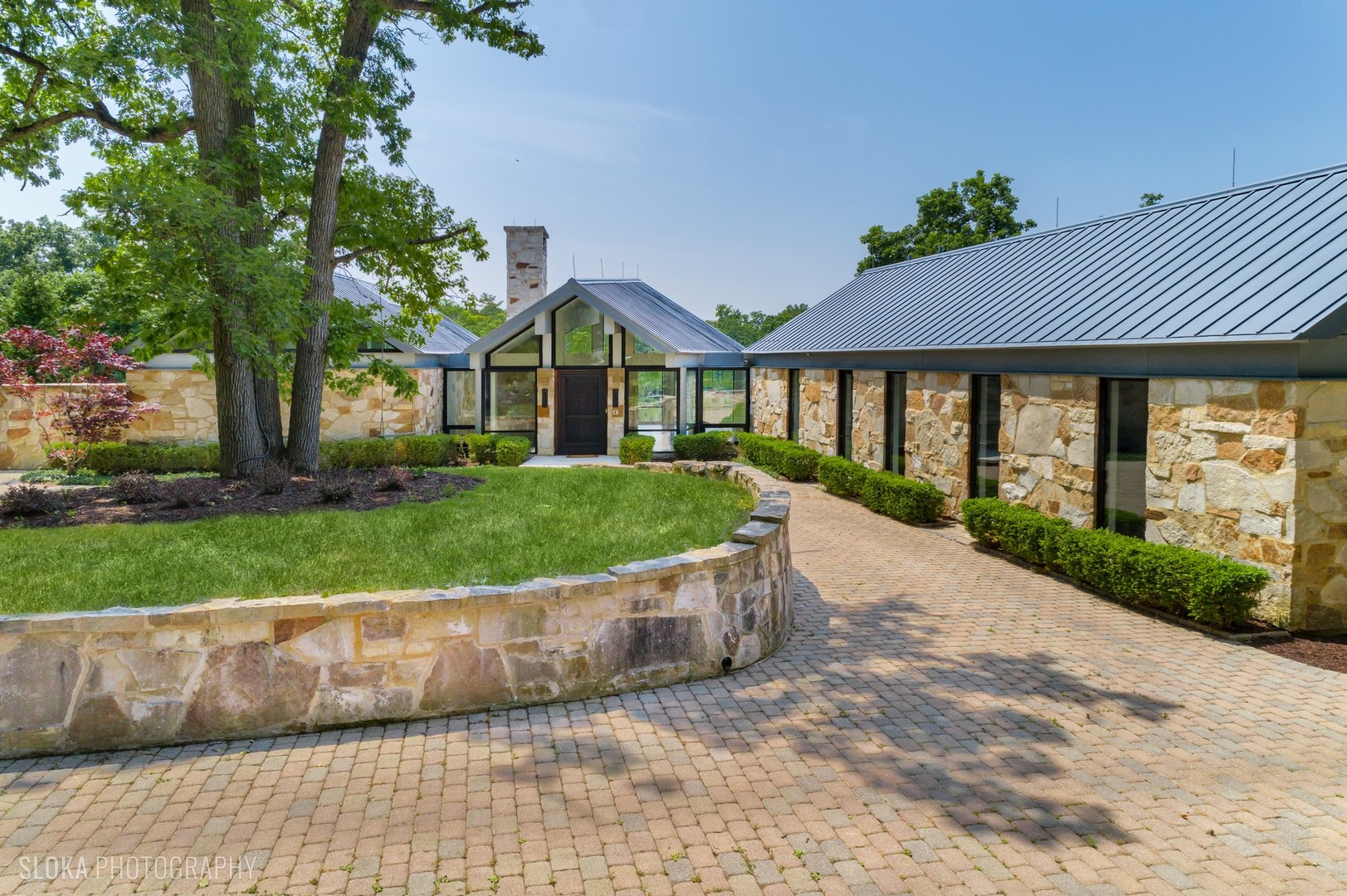 a view of a house with a small yard and a large tree