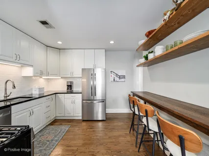 a kitchen with stainless steel appliances granite countertop a refrigerator and a stove top oven