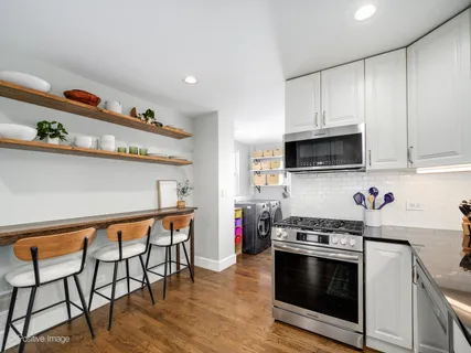 a kitchen with stainless steel appliances a stove a microwave a sink and cabinets
