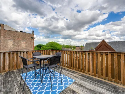 a view of a roof deck with table and chairs