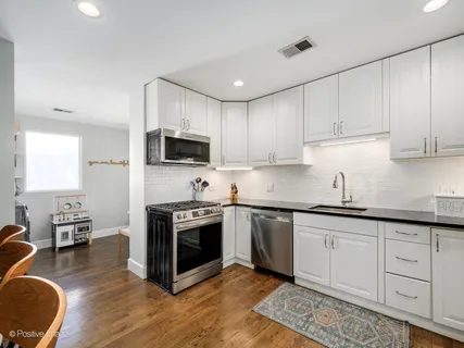 a kitchen with stainless steel appliances granite countertop a stove sink and cabinets