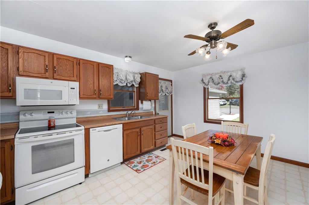 232 Pfeifer Road Harmony, PA 16037 - Photo 10 of 33 a kitchen with stainless steel appliances kitchen island granite countertop a sink a stove a dining table and chairs with wooden floor