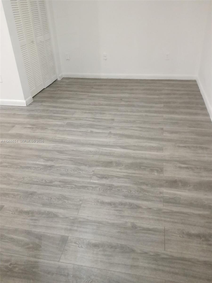 7130 Rue Versailles Drive, Unit 3 Miami Beach, FL 33141 - Photo 15 of 17 a view of an empty room with wooden floor