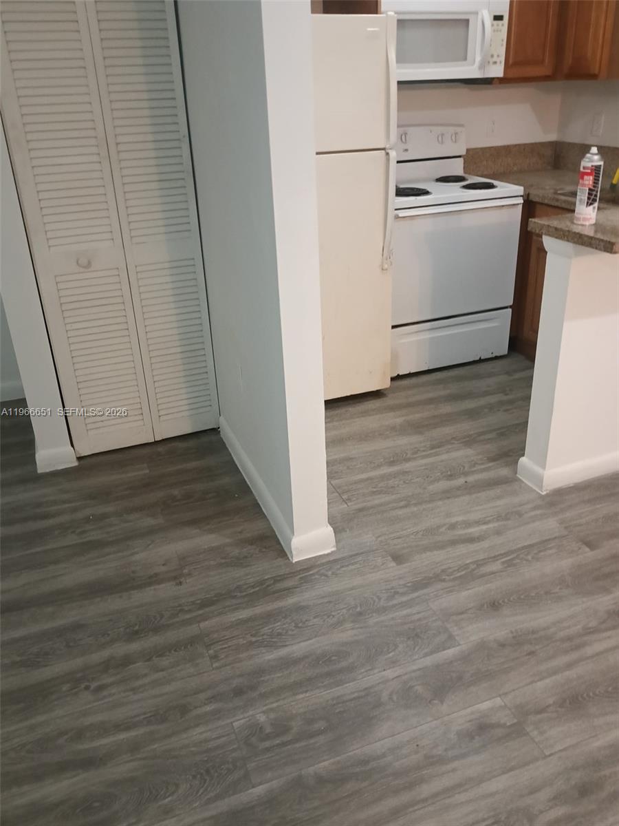 7130 Rue Versailles Drive, Unit 3 Miami Beach, FL 33141 - Photo 17 of 17 a kitchen with a white cabinets and wooden floor