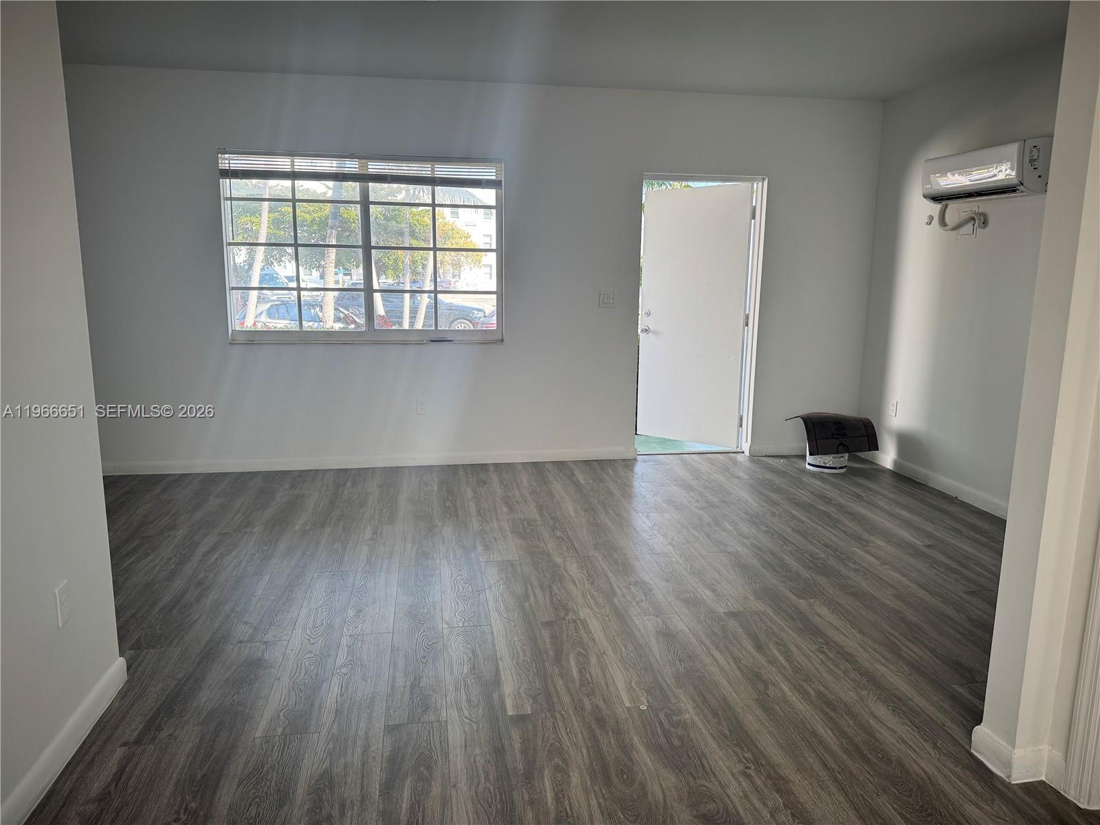 7130 Rue Versailles Drive, Unit 3 Miami Beach, FL 33141 - Photo 2 of 17 an empty room with wooden floor and windows