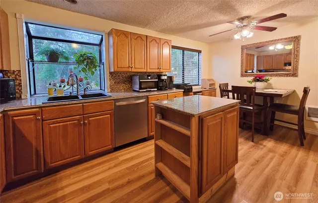 a kitchen with wooden cabinets a sink dishwasher and a stove with wooden floor