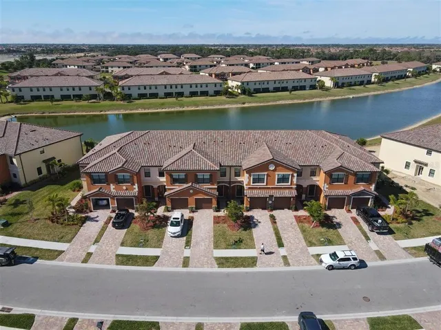 an aerial view of a house with a garden and lake view