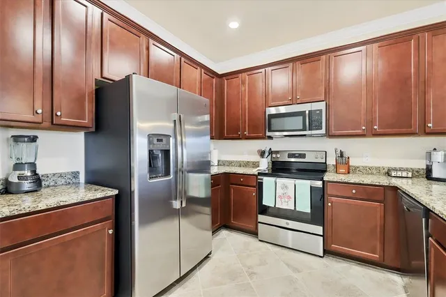a kitchen with granite countertop a refrigerator stove top oven a sink and dishwasher