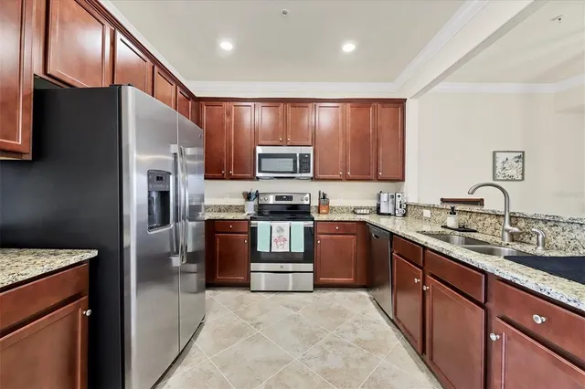 a kitchen with stainless steel appliances granite countertop a refrigerator stove and sink