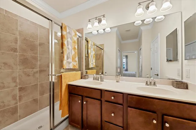 a bathroom with a double vanity sink mirror and shower