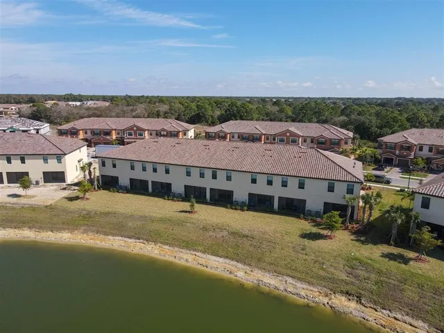 a view of a big house with a big yard and large trees