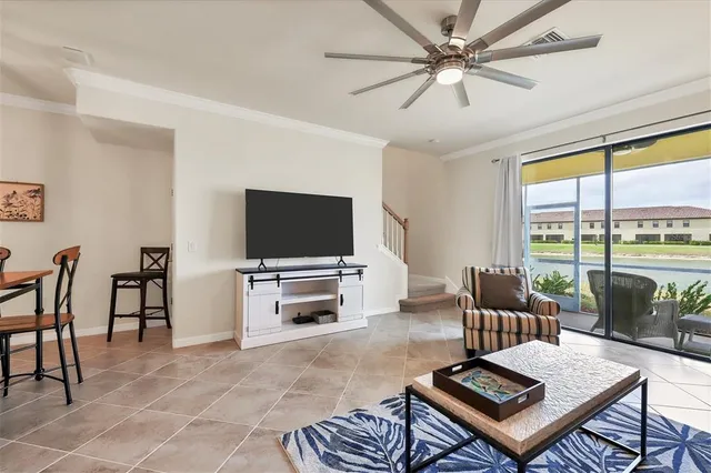 a living room with furniture a flat screen tv and a large window