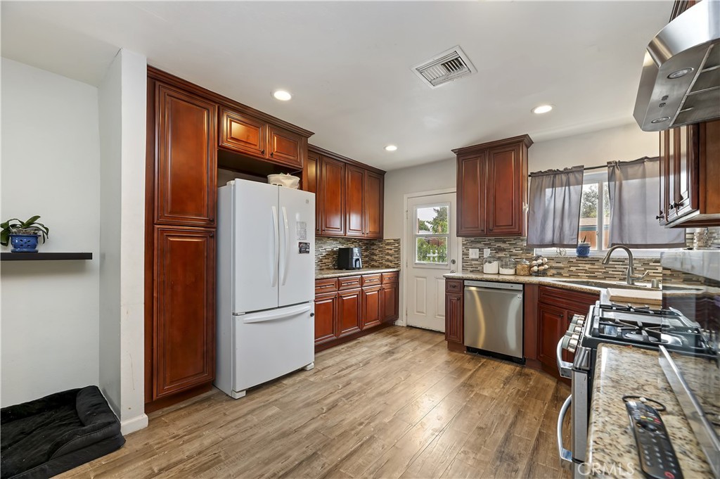 3075 Ronald Street Riverside, CA 92506 - Photo 11 of 30 a kitchen with granite countertop stainless steel appliances a refrigerator a stove top oven and a center island