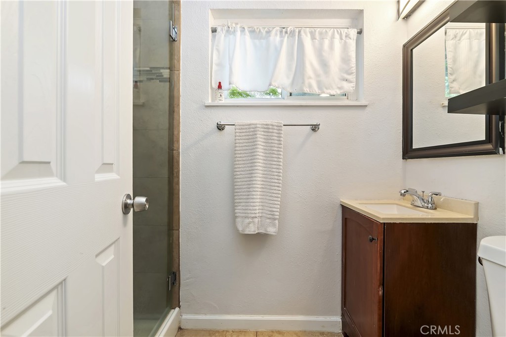 3075 Ronald Street Riverside, CA 92506 - Photo 22 of 30 a bathroom with a sink and mirror with window