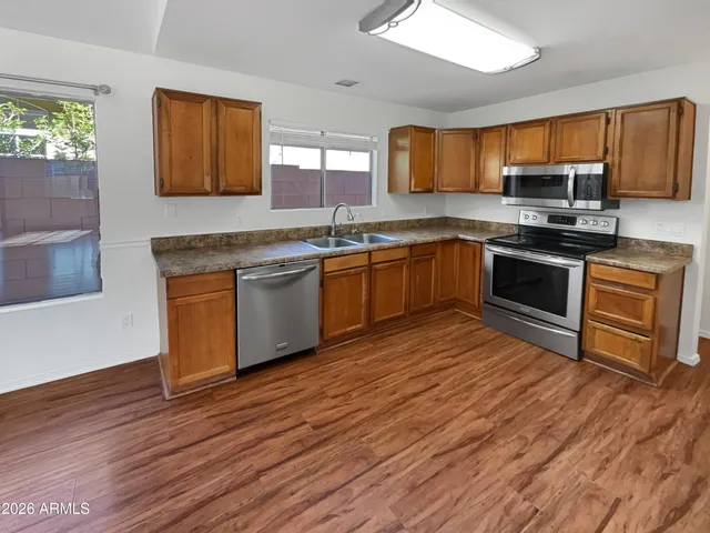 a kitchen with stainless steel appliances granite countertop a stove a sink and a microwave