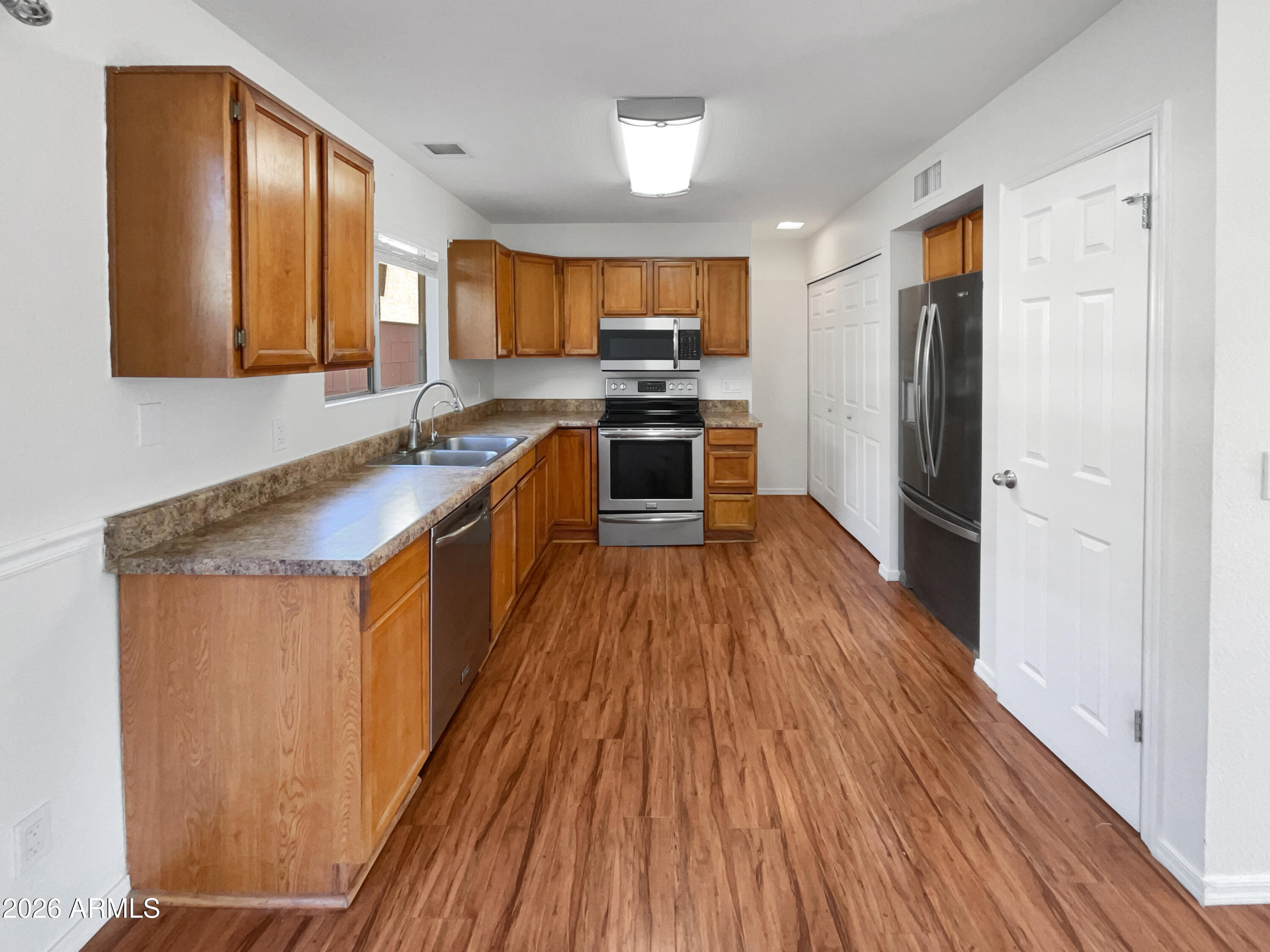 19002 North 14th Place Phoenix, AZ 85024 - Photo 2 of 27 a large kitchen with stainless steel appliances granite countertop a refrigerator a sink dishwasher a stove and white countertops with wooden floor