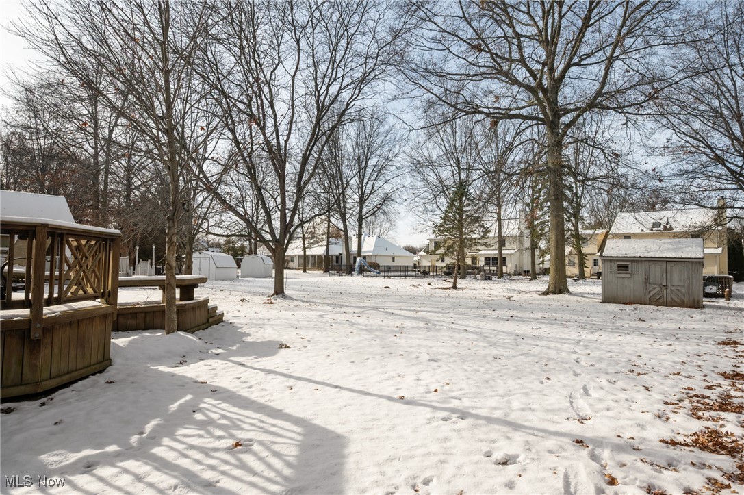 9132 Reed Road North Ridgeville, OH 44039 - Photo 35 of 43 Yard layered in snow with a storage shed, a residential view, and a deck