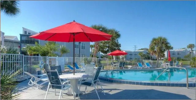 a view of patio with chairs and table under an umbrella