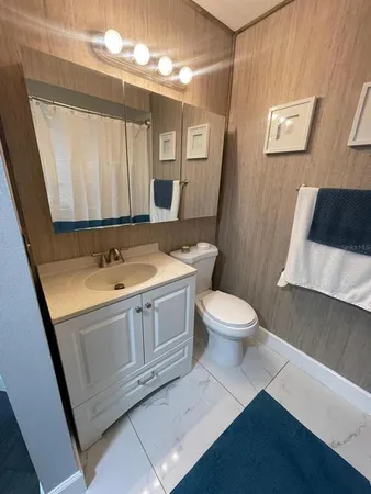 a bathroom with a sink a toilet a mirror and shower