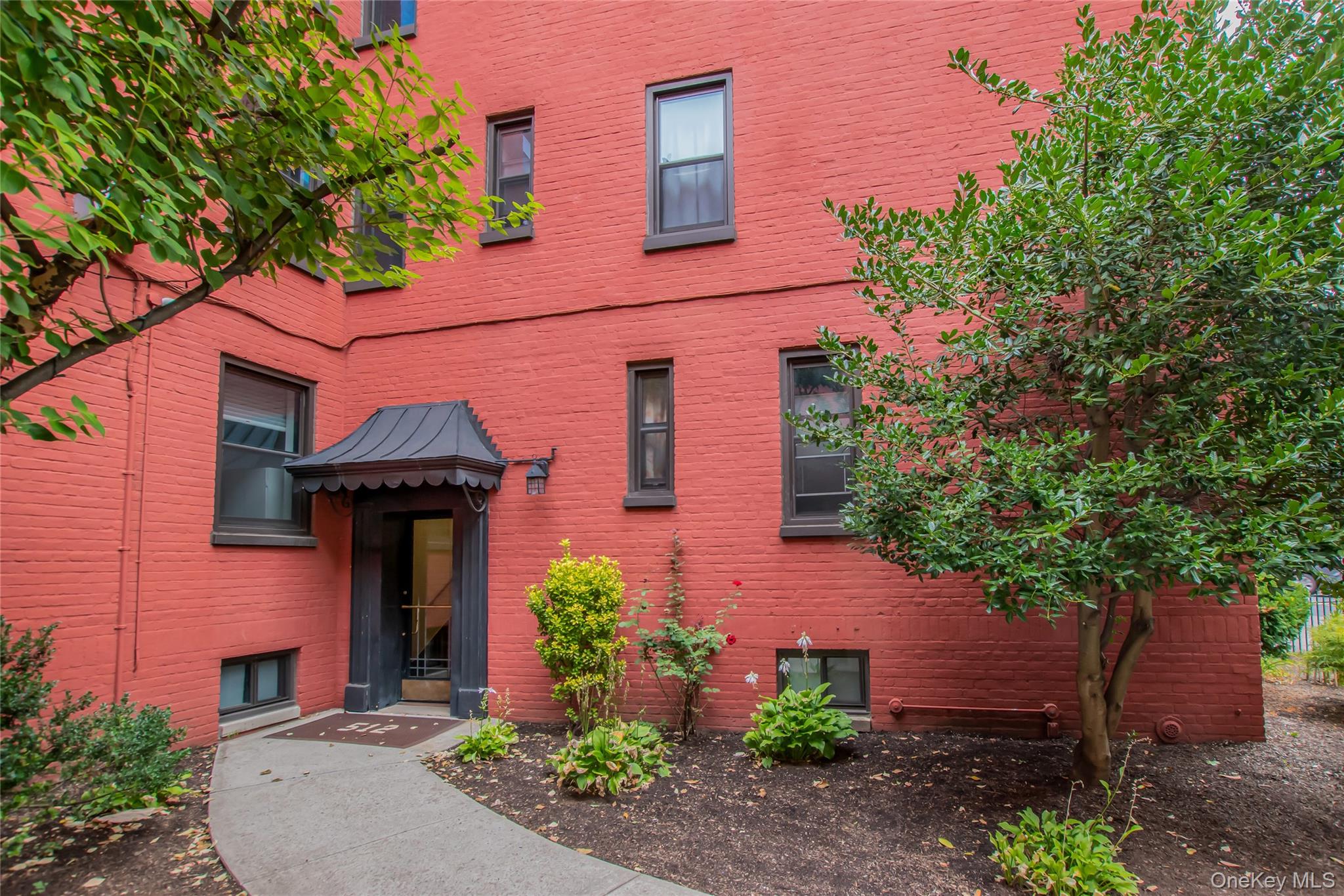 512 Kappock Street, Unit 1K Bronx, NY 10463 - Photo 11 of 11 a front view of a house with plants and trees