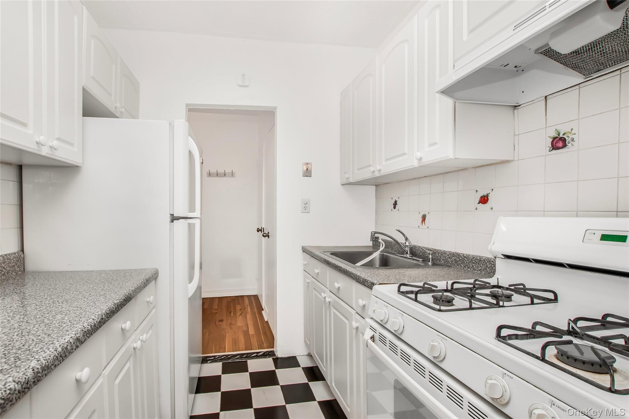 512 Kappock Street, Unit 1K Bronx, NY 10463 - Photo 4 of 11 a kitchen with a stove and a refrigerator