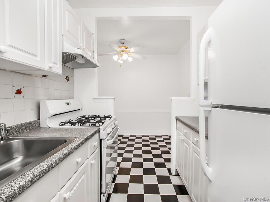512 Kappock Street, Unit 1K Bronx, NY 10463 - Photo 5 of 11 a kitchen with a sink a stove and cabinets