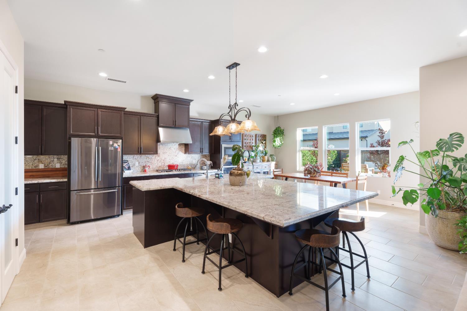 822 Overstone Avenue Madera, CA 93636 - Photo 47 of 49 a room with granite countertop stainless steel appliances a dining table chairs and refrigerator