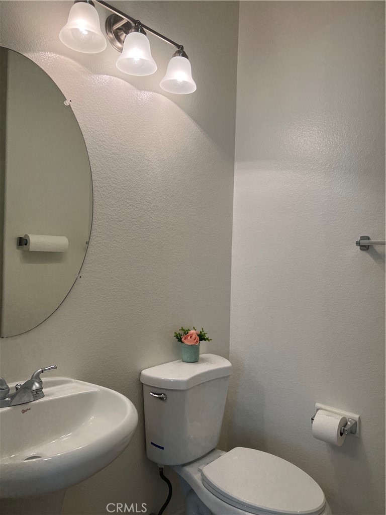 12772 Clemson Drive Eastvale, CA 92880 - Photo 11 of 28 a white toilet sitting next to a bathroom sink