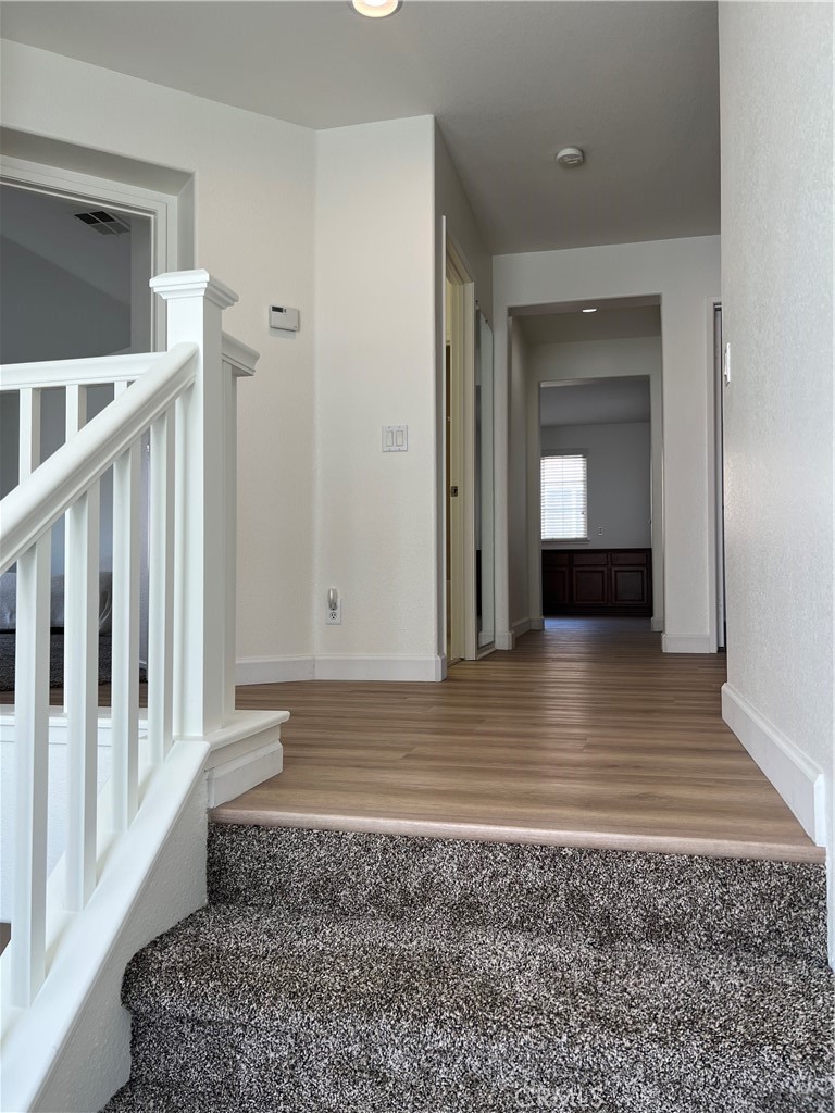 12772 Clemson Drive Eastvale, CA 92880 - Photo 14 of 28 a view of a hallway view with wooden floor and staircase