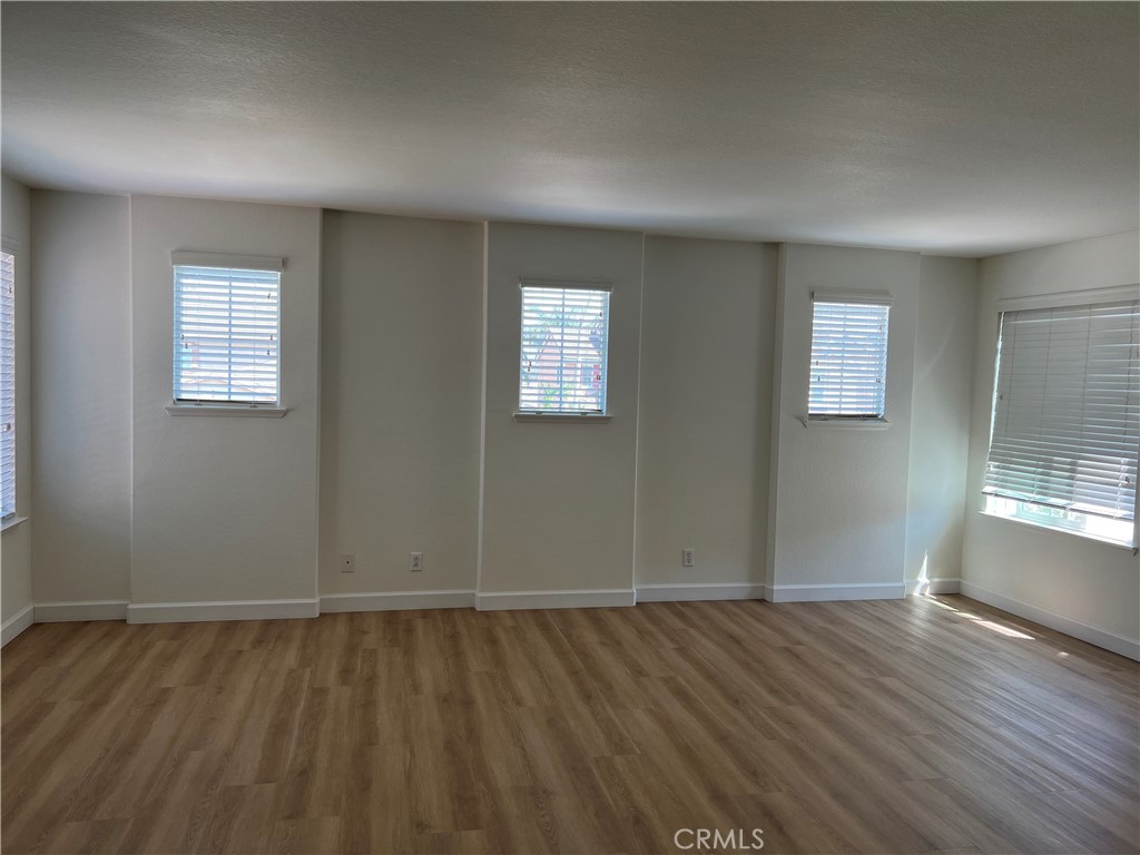 12772 Clemson Drive Eastvale, CA 92880 - Photo 26 of 28 an empty room with wooden floor and windows