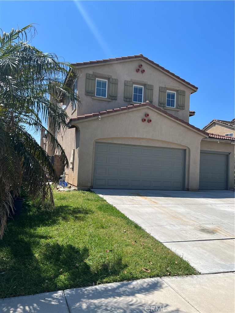12772 Clemson Drive Eastvale, CA 92880 - Photo 3 of 28 a front view of a house with a yard and garage