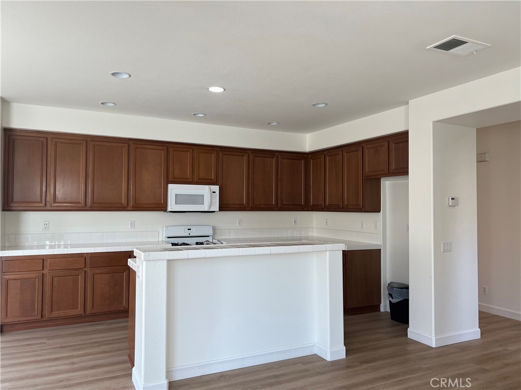 12772 Clemson Drive Eastvale, CA 92880 - Photo 6 of 28 a kitchen with a stove a refrigerator and a sink