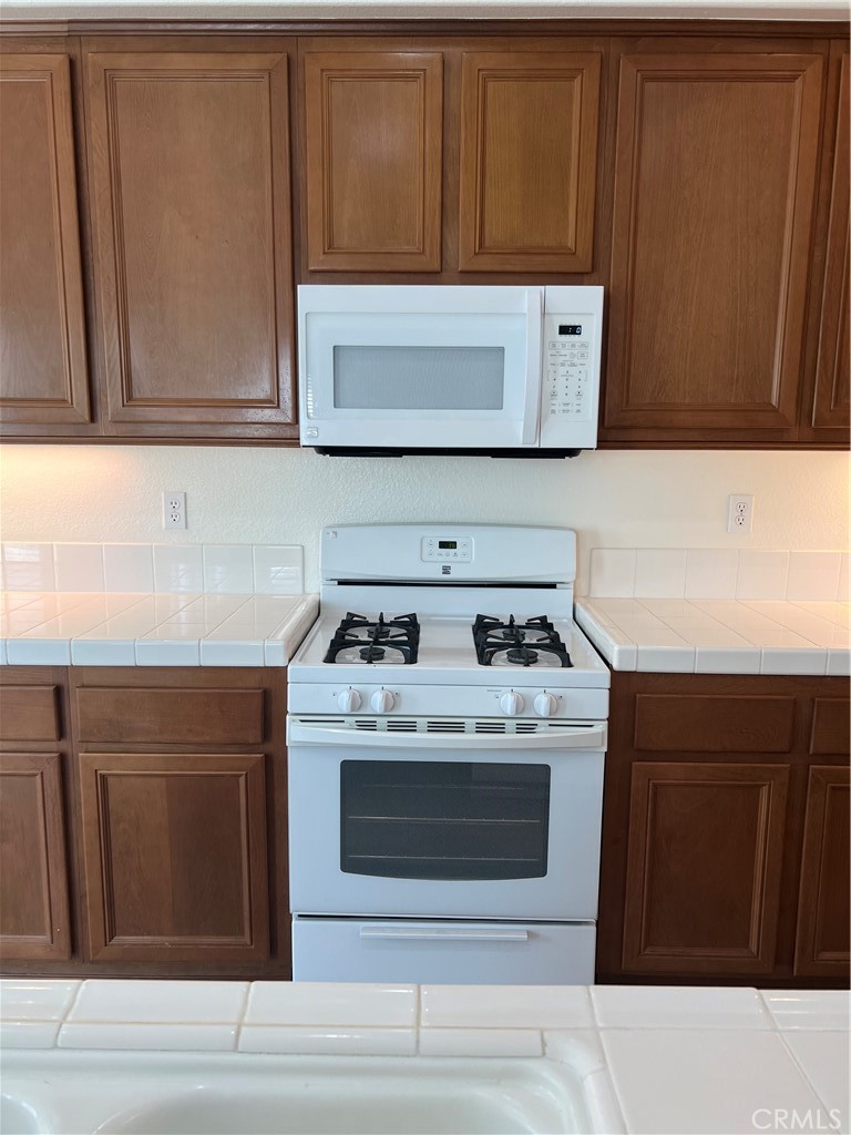 12772 Clemson Drive Eastvale, CA 92880 - Photo 7 of 28 a stove top oven sitting inside of a kitchen