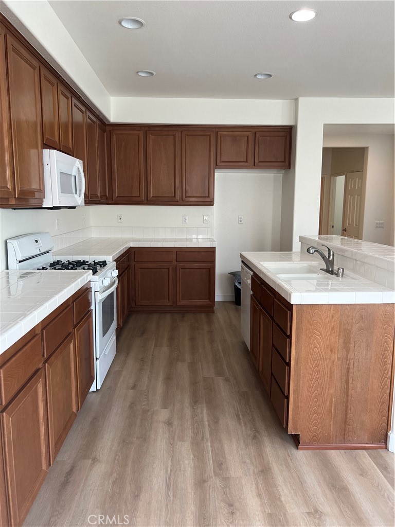 12772 Clemson Drive Eastvale, CA 92880 - Photo 8 of 28 a kitchen with a sink stove top oven and cabinets