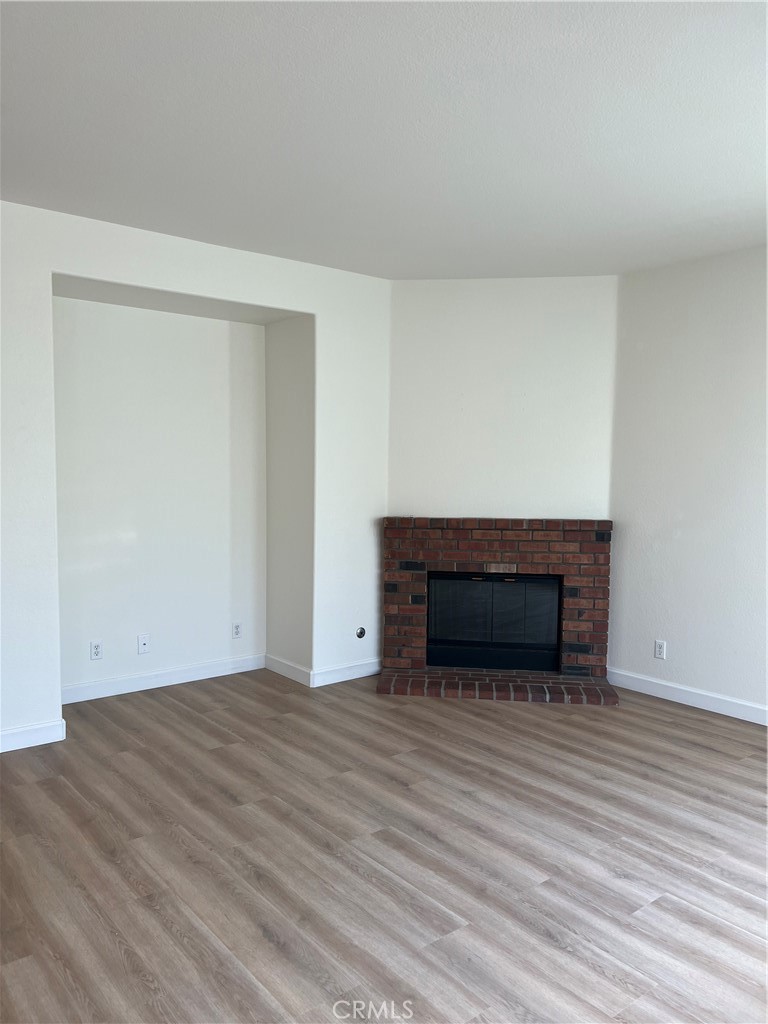 12772 Clemson Drive Eastvale, CA 92880 - Photo 9 of 28 a view of an empty room with wooden floor and a fireplace