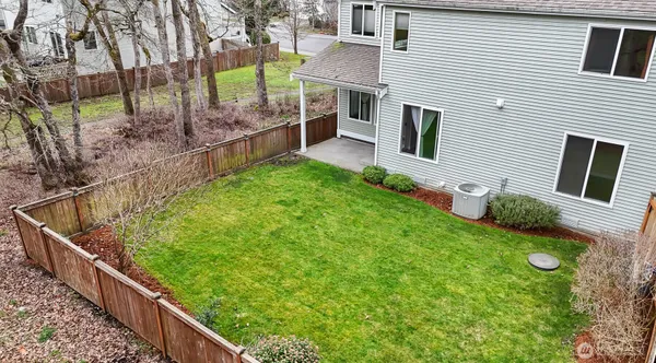 a view of a house with backyard and wooden fence