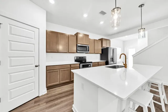 a kitchen with stainless steel appliances granite countertop a sink a stove and a refrigerator