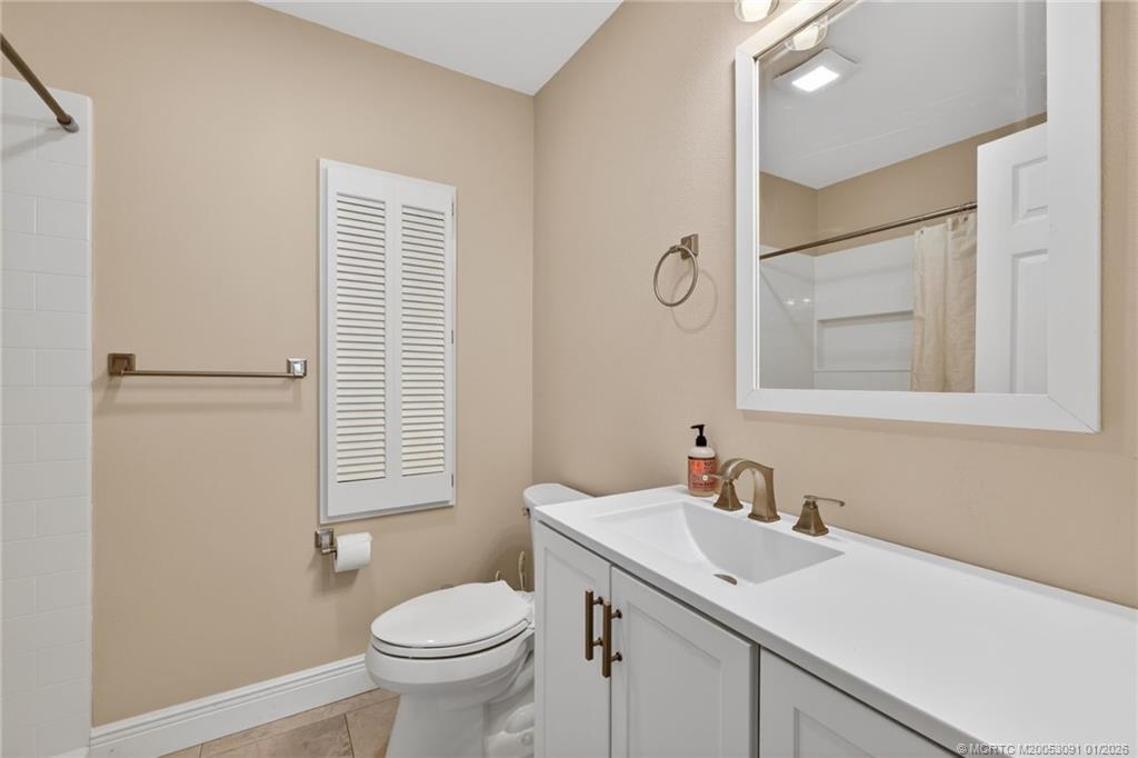 607 Southeast Cortez Avenue Stuart, FL 34994 - Photo 19 of 29 a bathroom with a granite countertop sink toilet and mirror