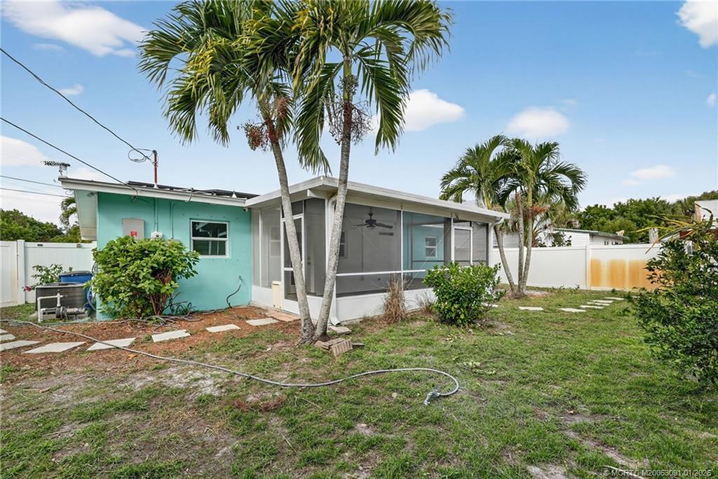 607 Southeast Cortez Avenue Stuart, FL 34994 - Photo 26 of 29 a view of a house with a yard and palm trees