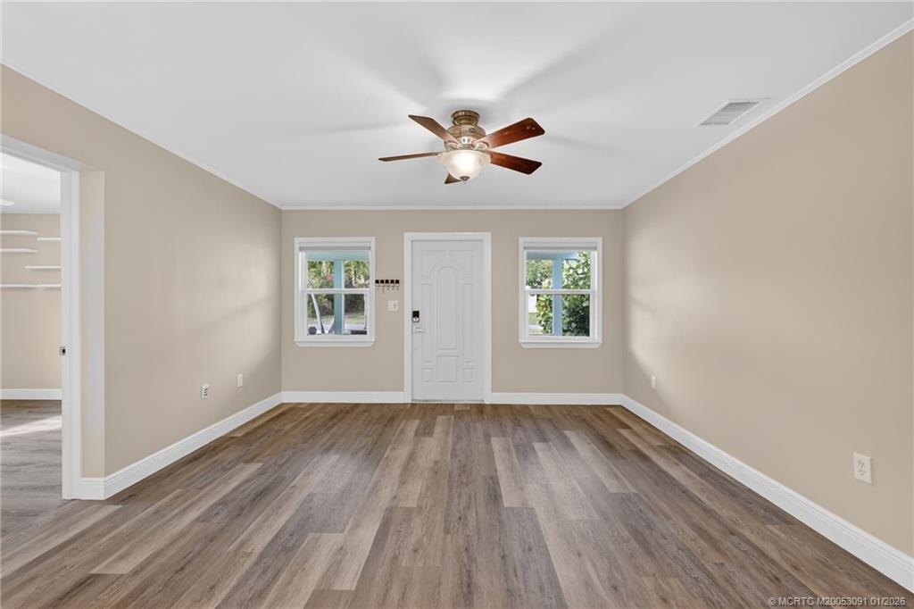 607 Southeast Cortez Avenue Stuart, FL 34994 - Photo 5 of 29 a view of empty room with wooden floor and fan