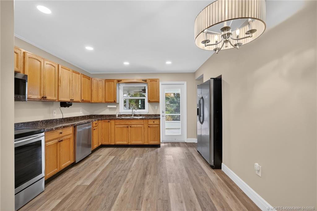 607 Southeast Cortez Avenue Stuart, FL 34994 - Photo 7 of 29 a large kitchen with stainless steel appliances granite countertop a lot of counter space and wooden floors