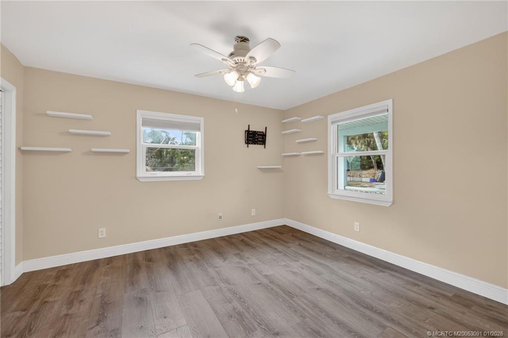 607 Southeast Cortez Avenue Stuart, FL 34994 - Photo 9 of 29 a view of a room with wooden floor and chandelier fan