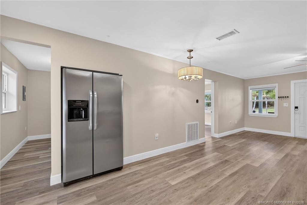 607 Southeast Cortez Avenue Stuart, FL 34994 - Photo 10 of 29 an empty room with wooden floor and windows